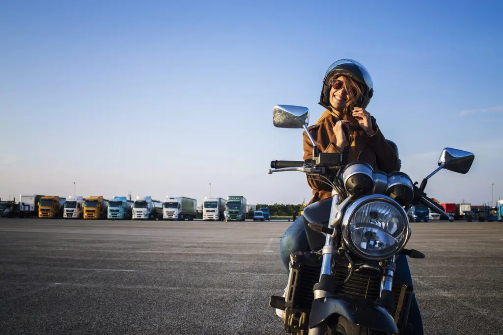 Femme qui retire son casque sur sa moto